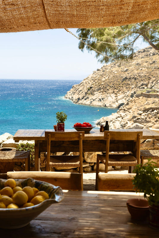 Table with some bowls of lemons and tomatoes overlooking the sea